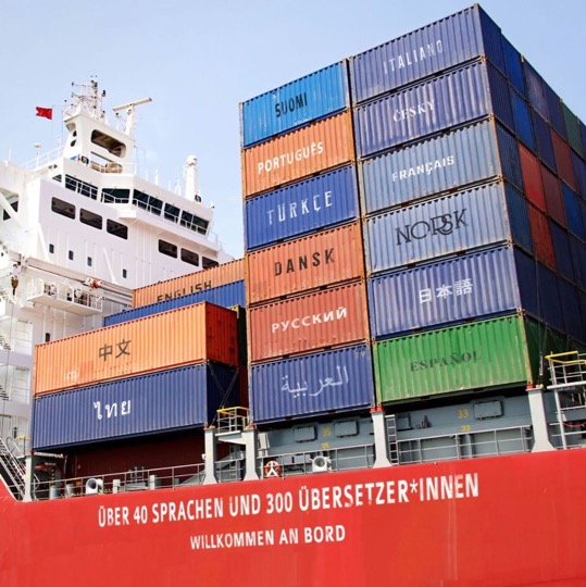 Containerschiff mit Beschriftung: Über 40 Sprachen und 300 Übersetzer:innen